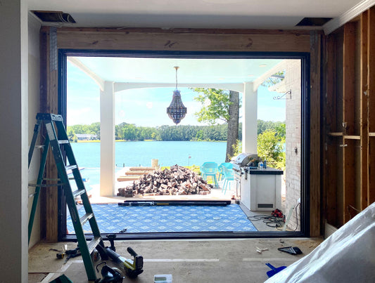 Aluminum sliding door installation overlooking a lakeside patio and scenic waterfront view.