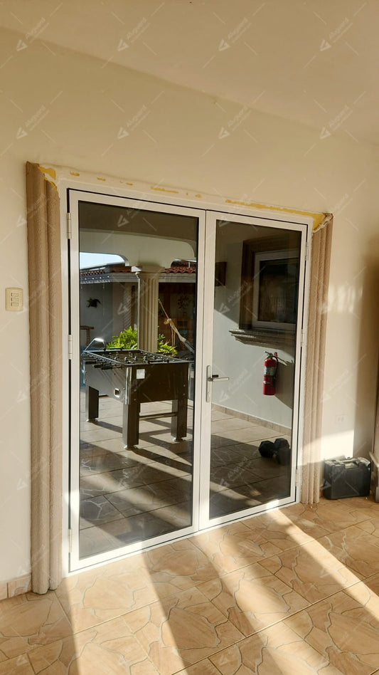 White aluminum alloy double-leaf glass doors featuring a design that maximizes transparency and natural light, installed in the transitional area between indoor and outdoor spaces.