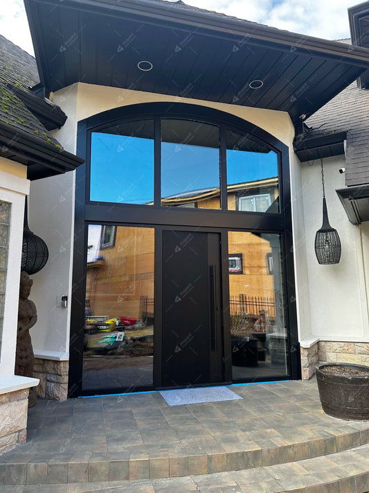 Black aluminum entry door with large glass sidelights and arched transom windows at a residential entrance.