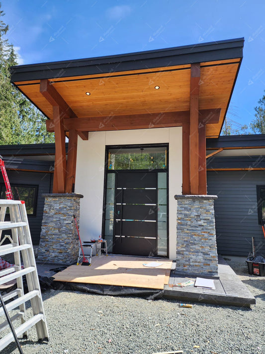Black aluminum entry door with glass sidelights installed at a modern home entrance.